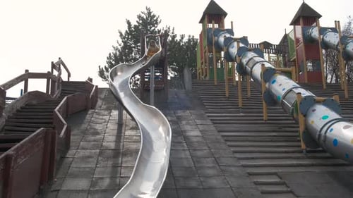 Teen Slide Down Hill on Playground