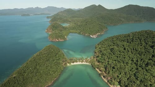 forward aerial dolly high angle of tropical islands, turquoise waters with white sand beach, palms a