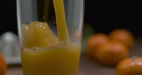 Tangerine juice poured into glass in close up