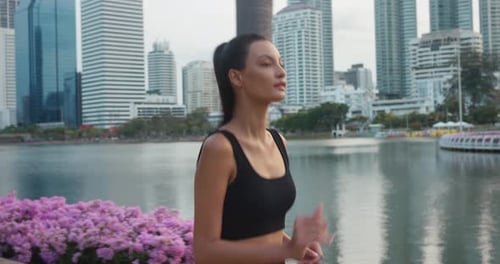 Female Athlete Engages Fitness Gracefully Jogging Along Lakeside Paths of City Park Woman Doing