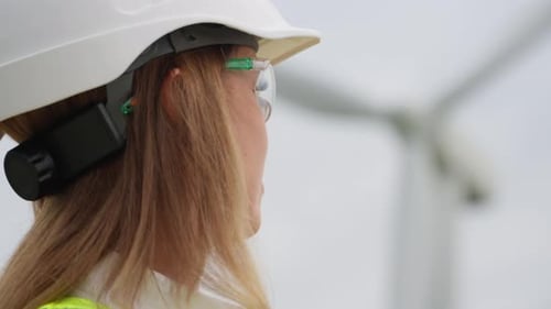 Female Engineer Smiling at Wind Turbine Farm