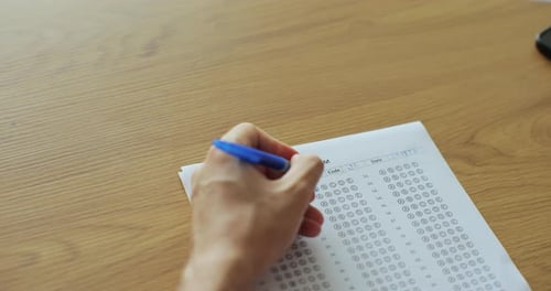 Schul- oder Universitätsstudenten: Hände beim Ablegen von Prüfungen, Schreiben, Prüfungsraum mit Stift in der Hand