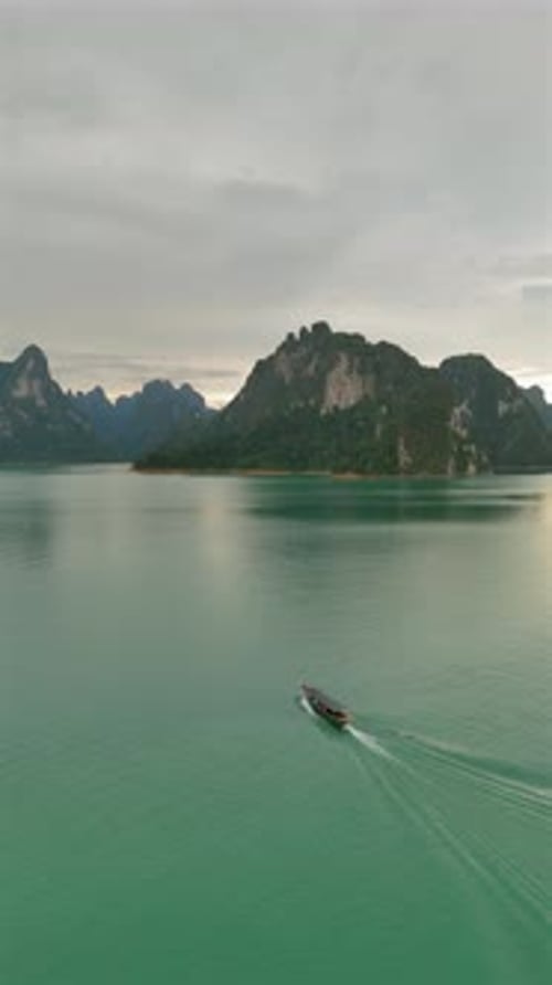 Boat Travels on Lake Surrounded by Mountains