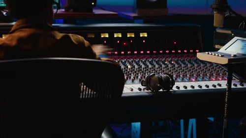 Audio Engineer with Mixing Board in Recording Studio