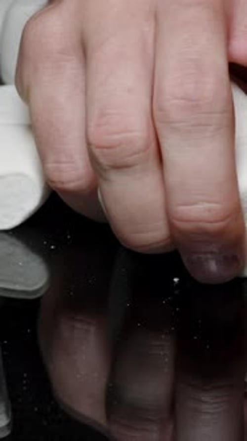 Vertical video. Hand Grabs a Pile of Sugar Marshmallows and Squeezes Them, Demonstrating Their Soft