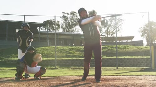 Playing baseball, batter holding bat while catcher and umpire ready on field