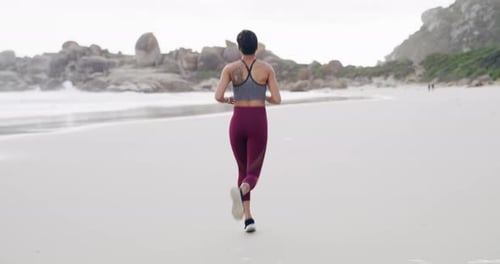 4k video footage of an attractive young sportswoman running on the beach