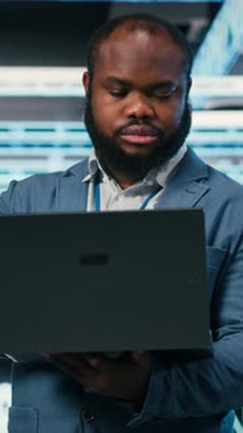 Vertical Video Happy Programmer in Server Hub Using Laptop to Do Maintenance Tasks
