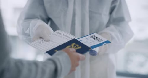 Traveler having his temperature checked by airport staff during the covid lockdown