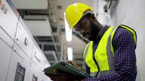 4K African man engineer working on digital tablet at factory control room.