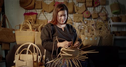 Une artisane asiatique qui est une villageoise locale qui tisse des paniers folkloriques