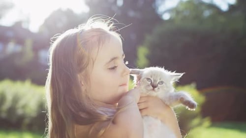 Little Cute Girl Sitting WITH Cute Kitty Cat In The Park