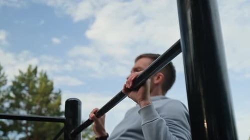 Primer plano de un joven haciendo flexiones en un área de entrenamiento al aire libre