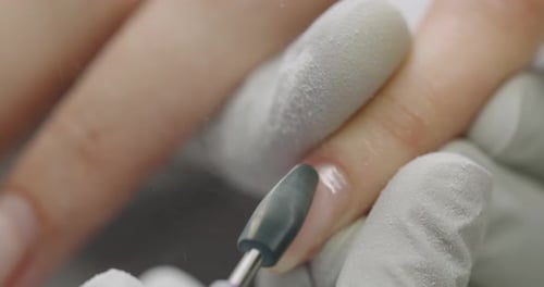 A Manicurist in Gloves Works with a Milling Machine