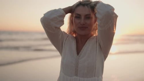 Woman Walking On Beach At Sunset
