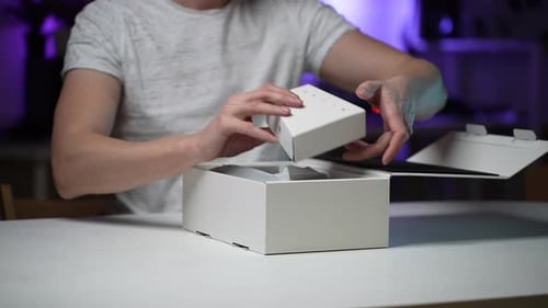 Détail en gros plan d'un caméraman masculin méconnaissable sortant des éléments d'un nouveau Steadicam de la boîte à table