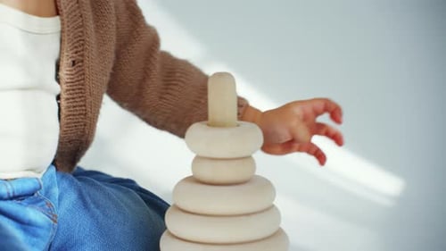 Kleines glückliches Kind spielt und sammelt Pyramidenspielzeug