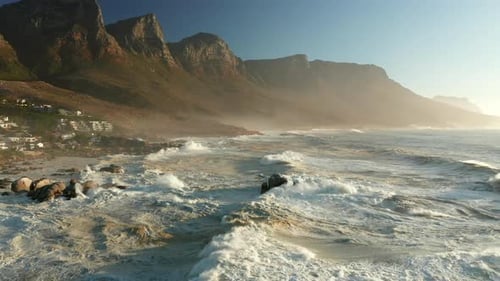 Ocean Waves Crashing On Rocky Coast Of Bakoven Beach At Sunrise In Cape Town, South Africa. - aerial