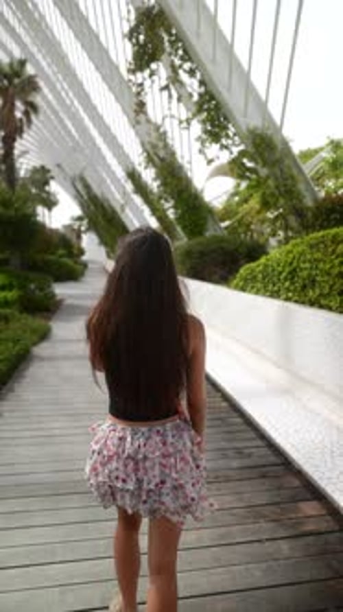 A Woman Walks in a Modern Botanical Garden Enjoying the Peaceful Green Surroundings