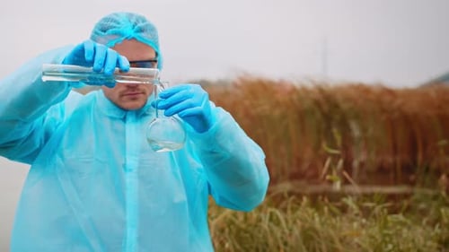 Scientist Analyzing Water Sample in Protective Suit