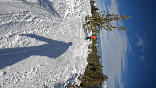 Snowboarder Rides Down Snowy Mountain Trail