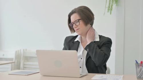 Woman Typing, Then Rubbing Neck in Office