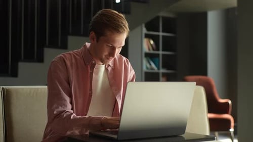 Man Using Laptop Indoors on Sofa