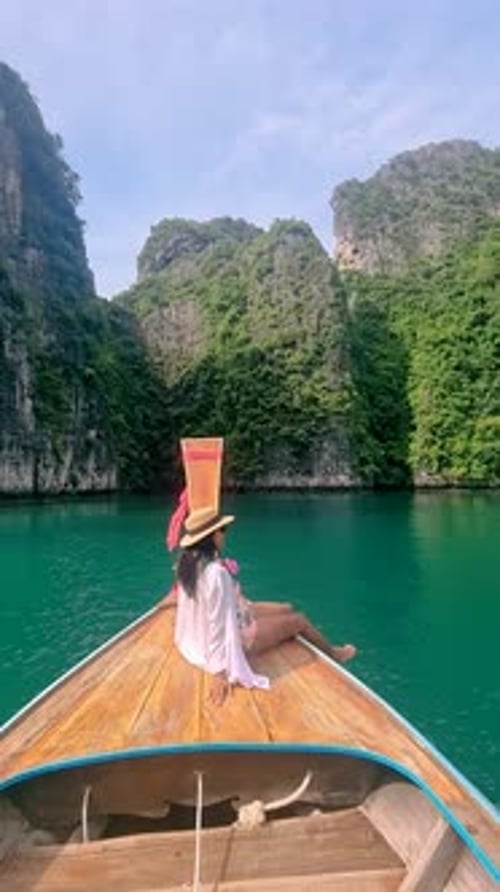Asian Women in Front of Longtail Boat with Green Blue Turqouse Lagoon at Koh Phi Phi Thailand