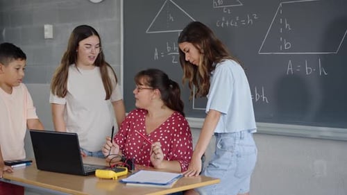 Enfants et étudiants apprenant l'électronique et la technologie avec un enseignant utilisant un ordinateur portable à l'école primaire