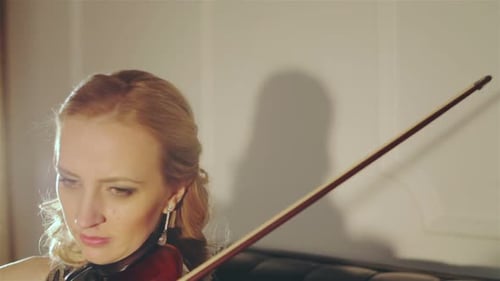 Elegant Woman Playing Violin in Soft Light