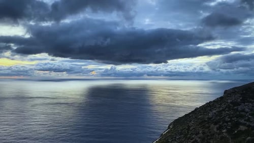 Dramatic timelapse sunset over the ocean with storm clouds. Large dark clouds moving across the sky.