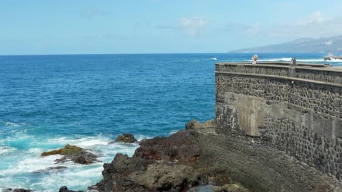 Woman carrying her child standing at the bay walk enjoying the scenery of the seaside, static slow m