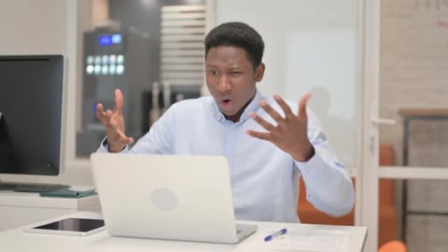 African Businessman Shocked by Loss on Laptop in Office