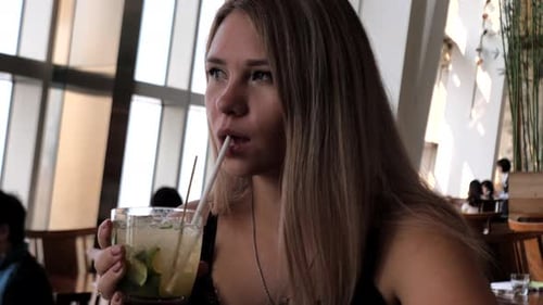 Closeup of Happy Woman Drinking Cocktail in Cafe in the City