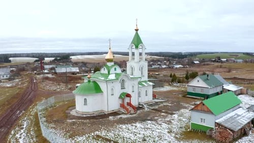 Green and white church on village background