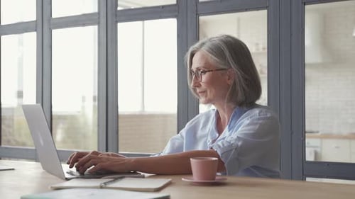Senior woman using laptop computer at table