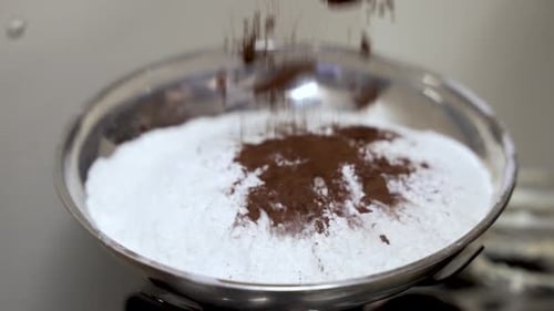 Cocoa Being Added to Flour in Bowl
