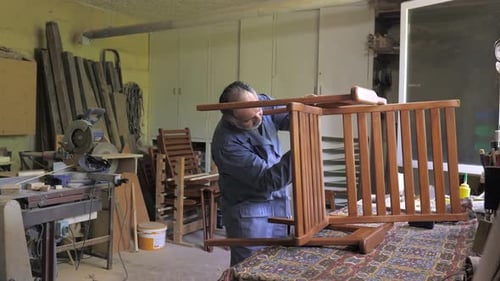 A Carpenter in His Workshop Assembles a Handmade Chair Screws a Bolt Secures It with a Hex Key