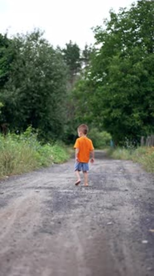 Barefoot Child Walking on a Rural Dirt Road