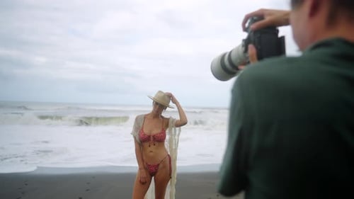 Dévoilement coulissant d'un mannequin sur une plage de sable noir photographié pour le contenu