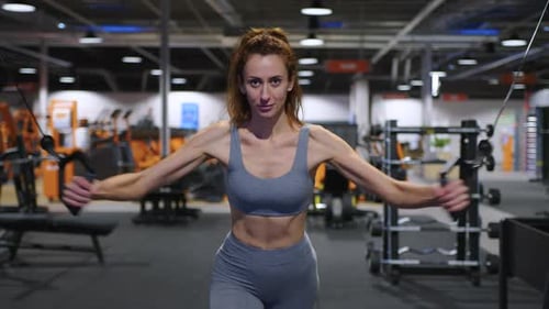 A Modern Advanced Woman Performs Sports Exercises in the Gym to Maintain a Beautiful Body Shape and