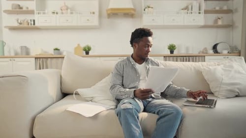 Young Adult Works from Home with Laptop