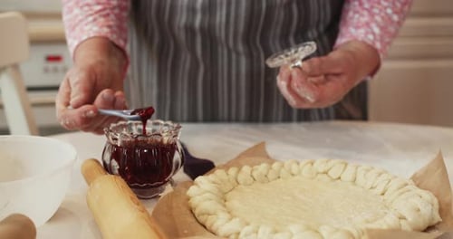 Woman Adding Berry Jam on Pie at Table