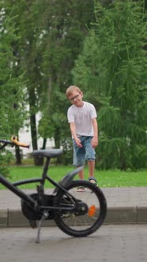 Niño se acerca juguetonamente y mueve el manillar de una bicicleta estacionada en Green Park