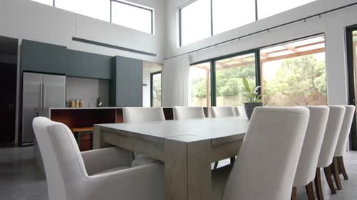 Interior of bright open plan dining room and kitchen with doors to garden, copy space, slow motion