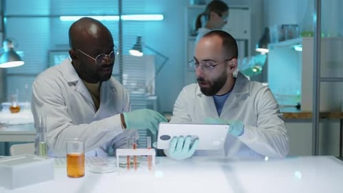 Multiethnic Male Scientists Discussing Research on Tablet Computer in Lab