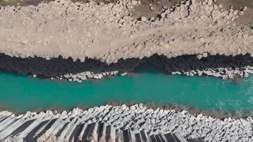 Stuðlagil unique basalt column rock formation in Iceland with turquoise glacial river, top down
