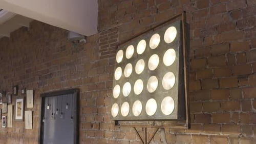 Industrial Design Light Fixture Turning on and Off on a Brick Wall