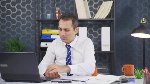 Tired Man Working At Desk in Office