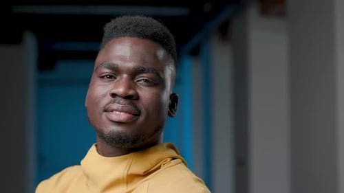 Smiling young man wearing yellow turtleneck indoors